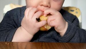 Ein sieben Monate altes Babz isst einen Apfel