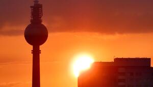 Silhouette des Berliner Fernsehturms und eines Gebäudes vor einem orangefarbenen ...