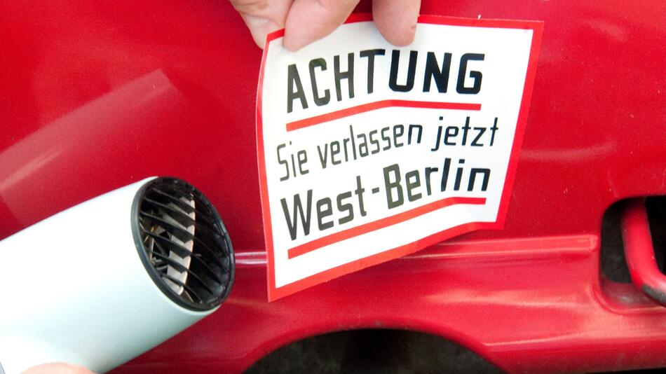 Ein Mann entfernt einen Aufkleber vom Auto