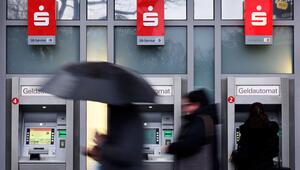 Menschen gehen an drei Bankautomaten vorbei.