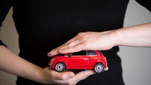 Eine Frau hält ein Modellauto in den Händen