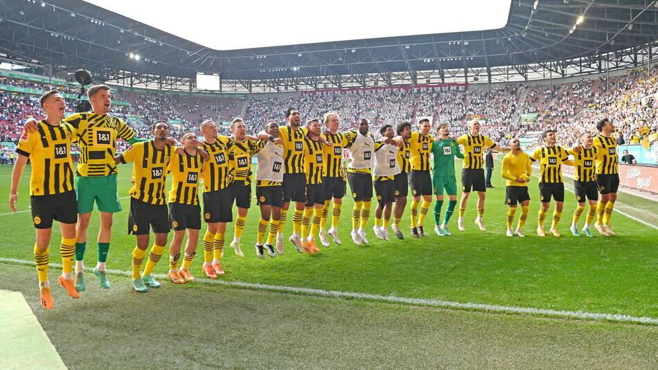 Die Spieler von Borussia Dortmund jubeln nach dem Sieg in Augsburg mit den mitgereisten Fans.
