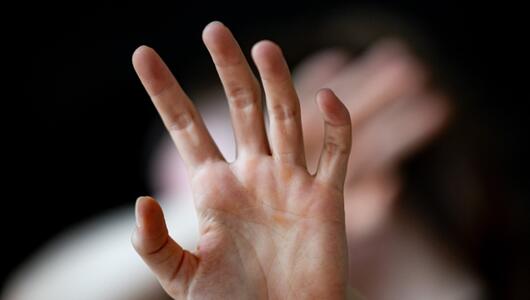 Hände werden schützend vor ein Gesicht gehalten