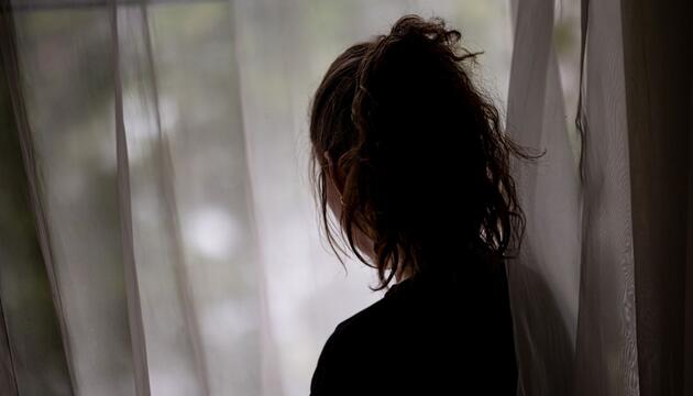 Eine Frau steht am Fenster