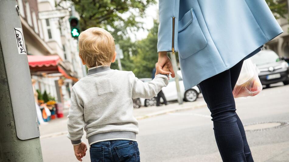 Eine Mutter mit Kind im Strassenverkehr