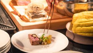 Ein Koch richtet sein Gericht auf einem Teller an