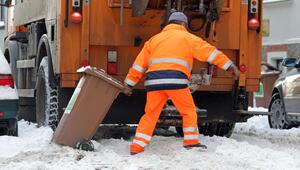 Mitarbeiter der Müllabfuhr entsorgt eine Biomülltonne