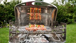 Gemüsespiesse und Fleisch liegen auf einem Grill
