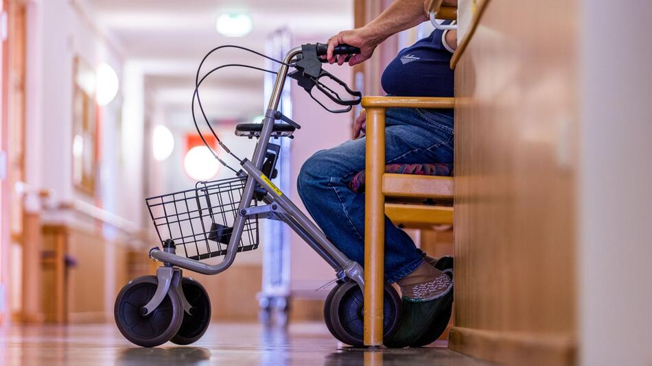 Bewohner sitzt mit seinem Rollator auf dem Flur eines Pflegeheims