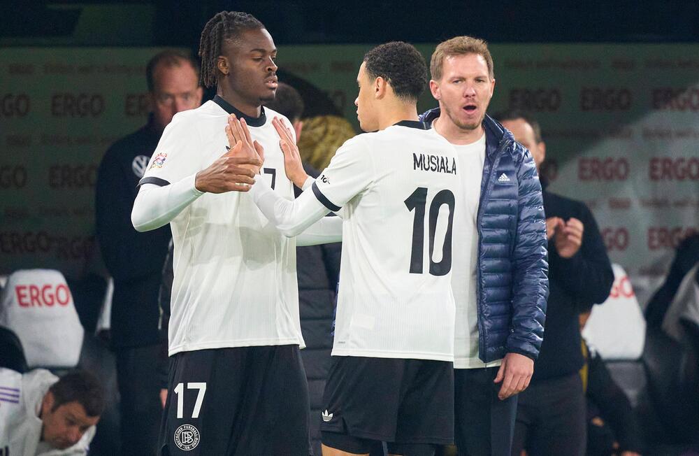 Bisseck (links) klatscht sich vor seiner Einwechslung mit DFB-Kollege Musiala ab.