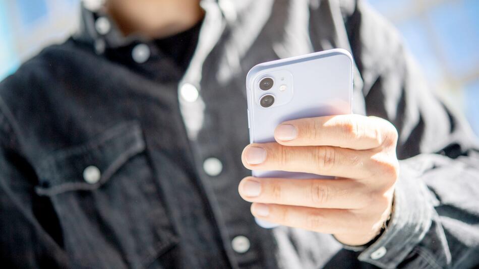 Ein Mann hält ein Smartphone in der Hand