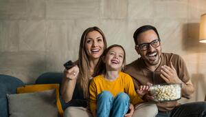 Familie sitzt gemeinsam vor dem Fernseher 