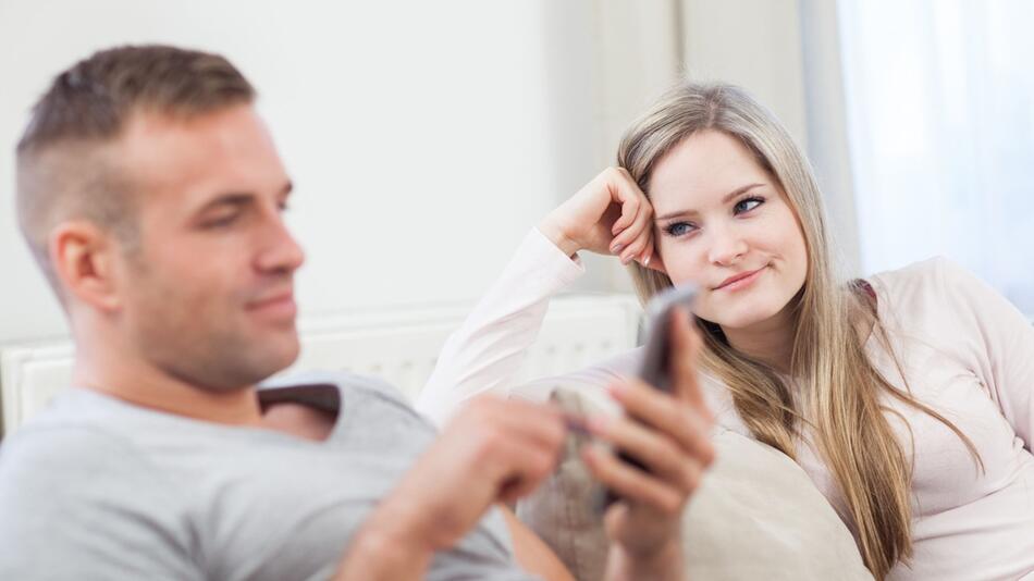 Frau schaut genervt zu ihrem Partner