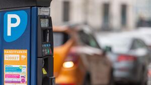 Parkscheinautomat steht vor parkenden Autos am Strassenrand