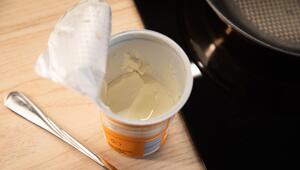 Geöffneter Becher Schmand steht in einer Küche