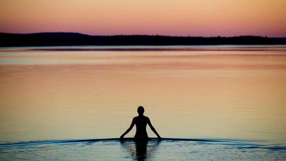 Frau badet an einem Sommerabend im Brombachsee