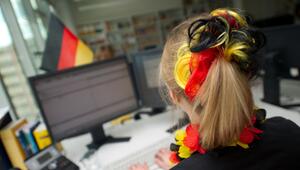 Eine Frau sitzt mit WM-Deko vor einem Computer