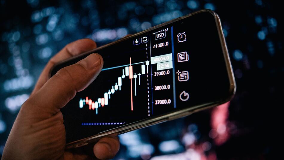 Mann schaut sich AKtienkurse auf dem Smartphone an