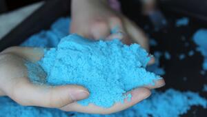 Zwei Hände halten blauen Knetsand.