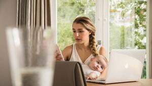 Eine Frau sitzt mit ihrem Baby am Computer