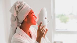 Frau setzt LED-Maske auf