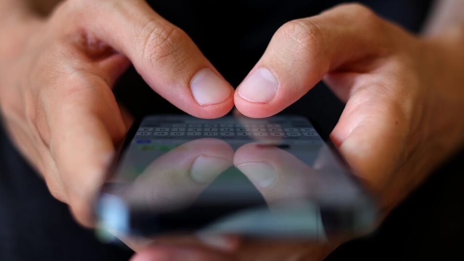Mann tippt auf einem Smartphone