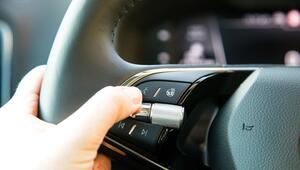 Eine Frau aktiviert die Sprachsteuerung in einem Auto