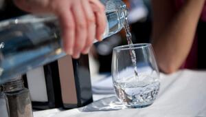 Mann giesst Wasser in ein Glas