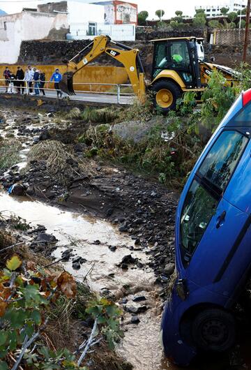 Ein blaues Auto ist durch die Überschwemmungen in einen Graben gerutscht.