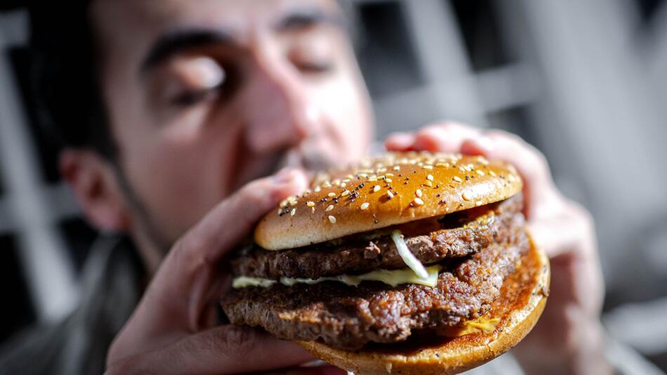 Mann beisst in einen Burger