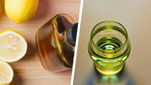 Halbierte und ganze Zitronen liegen auf einem Holzbrett neben einer braunen Glasflasche, daneben ...