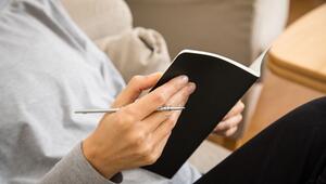 Eine Frau schreibt in ein Heft