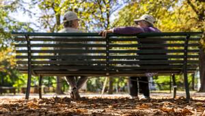 Zwei Personen sitzen auf einer Parkbank