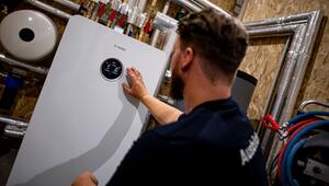 Handwerker zeigt an einer Wärmepumpe auf die Anzeige