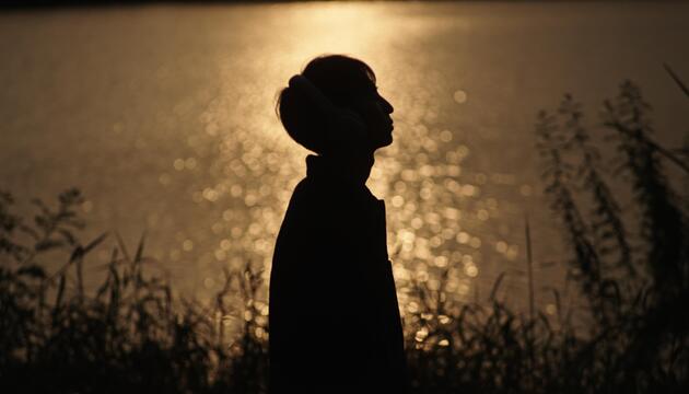 Mann im Gegenlicht am See. 