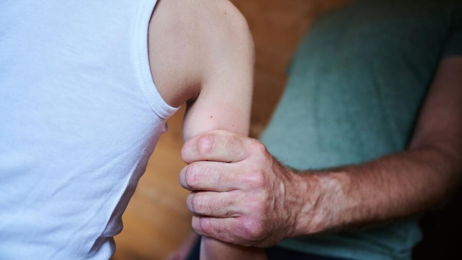 Symbolbild: Mann hält Kind am Arm fest
