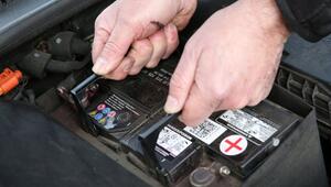 Mann wechselt eine Autobatterie