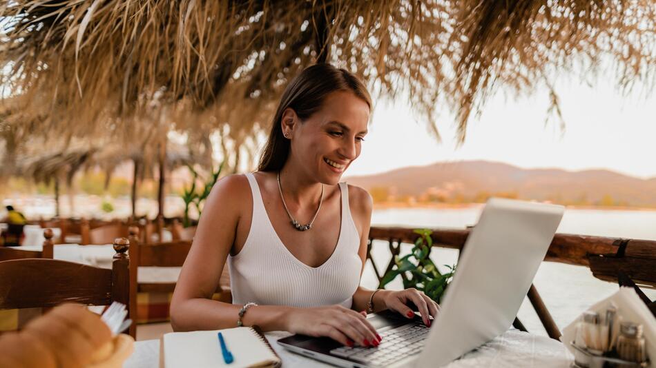 Eine Frau sitzt vor einem Laptop.