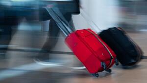 Mann zieht zwei Koffer durch das Terminal vom Flughafen BER