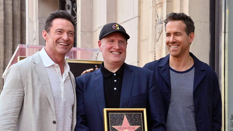 Hugh Jackman (l.) und Ryan Reynolds nehmen Marvel-Mastermind Kevin Feige in ihre Mitte.