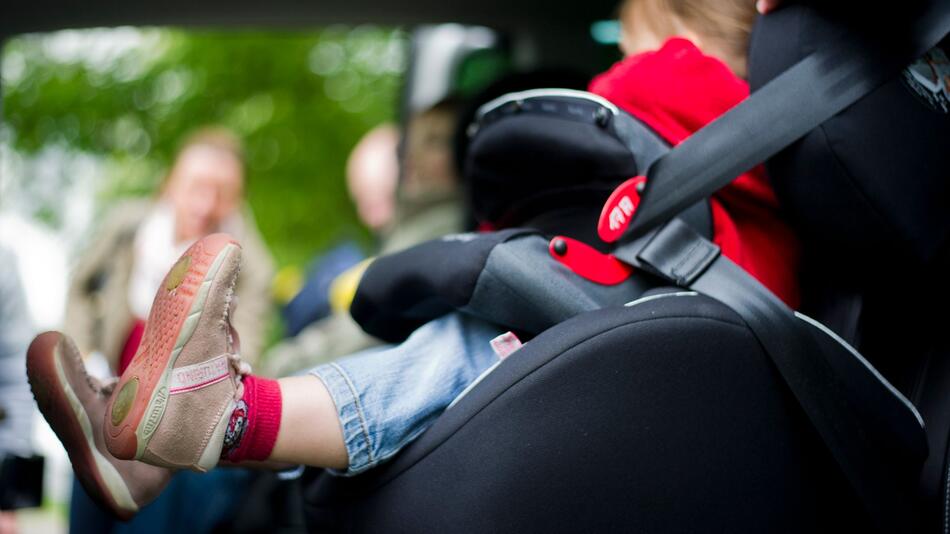 Mädchen sitzt in einem Kindersitz im Auto