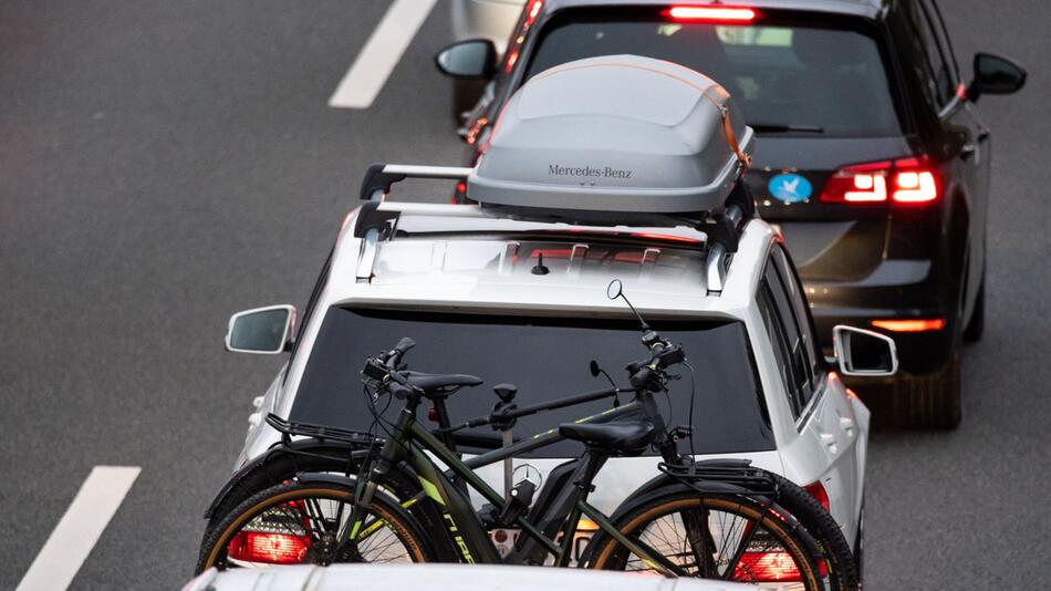 PKW mit Fahrrädern und Dachbox im Stau